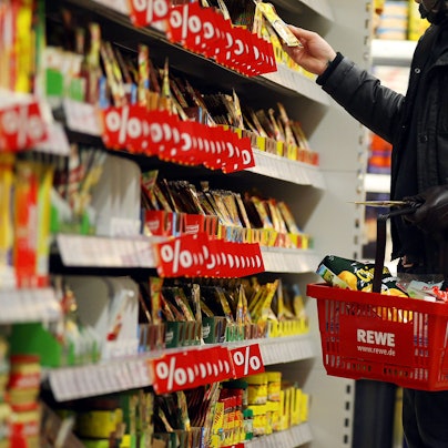 Ein Kunde steht in Köln in einem Rewe-Supermarkt an einem Regal. (Symbolbild)