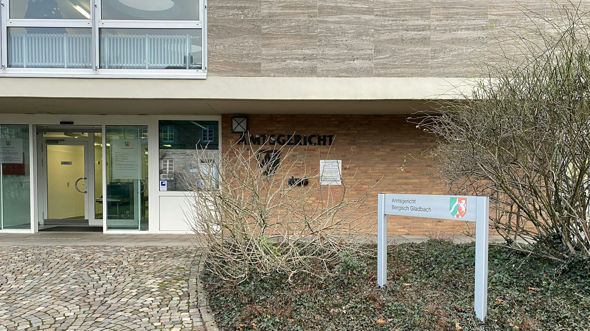 Das Gebäude vom Amtsgericht Bergisch Gladbach ist schmucklos und liegt auch im Winter unterhalb der prachtvollen Landmarke von Schloss Bensberg. Dieses Mal mit richtiger Benamselung.