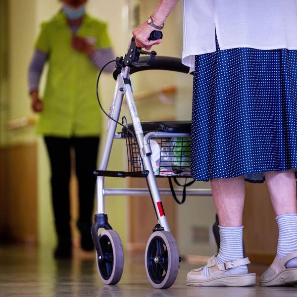 Frau mit Rollator begegnet einer Altenpflegerin
