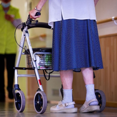 Frau mit Rollator begegnet einer Altenpflegerin
