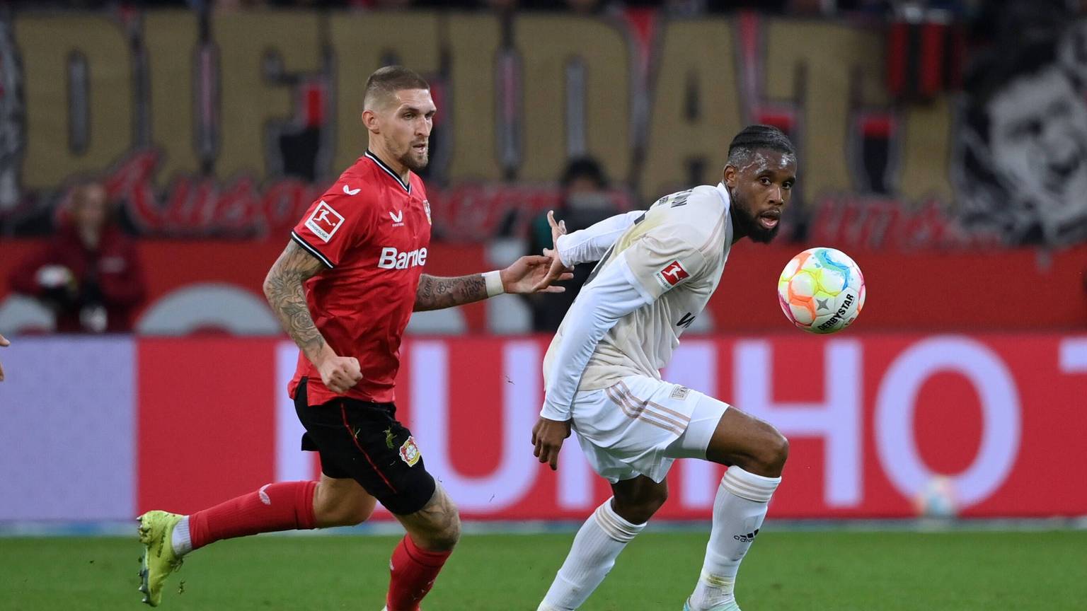 Robert Andrich von Bayer 04 Leverkusen im Spiel gegen Sheraldo Becker von Union Berlin.
