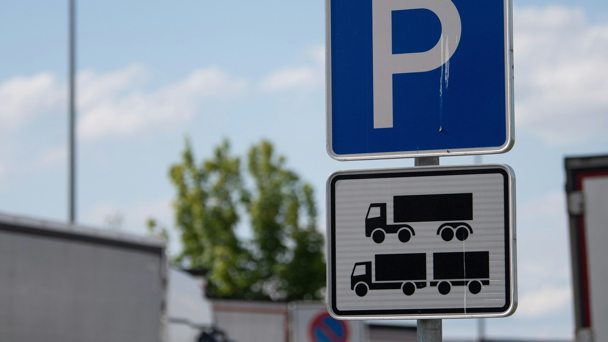 Ein Schild weist auf einer Rastanlage an der Autobahn auf einen Parkplatz hin.