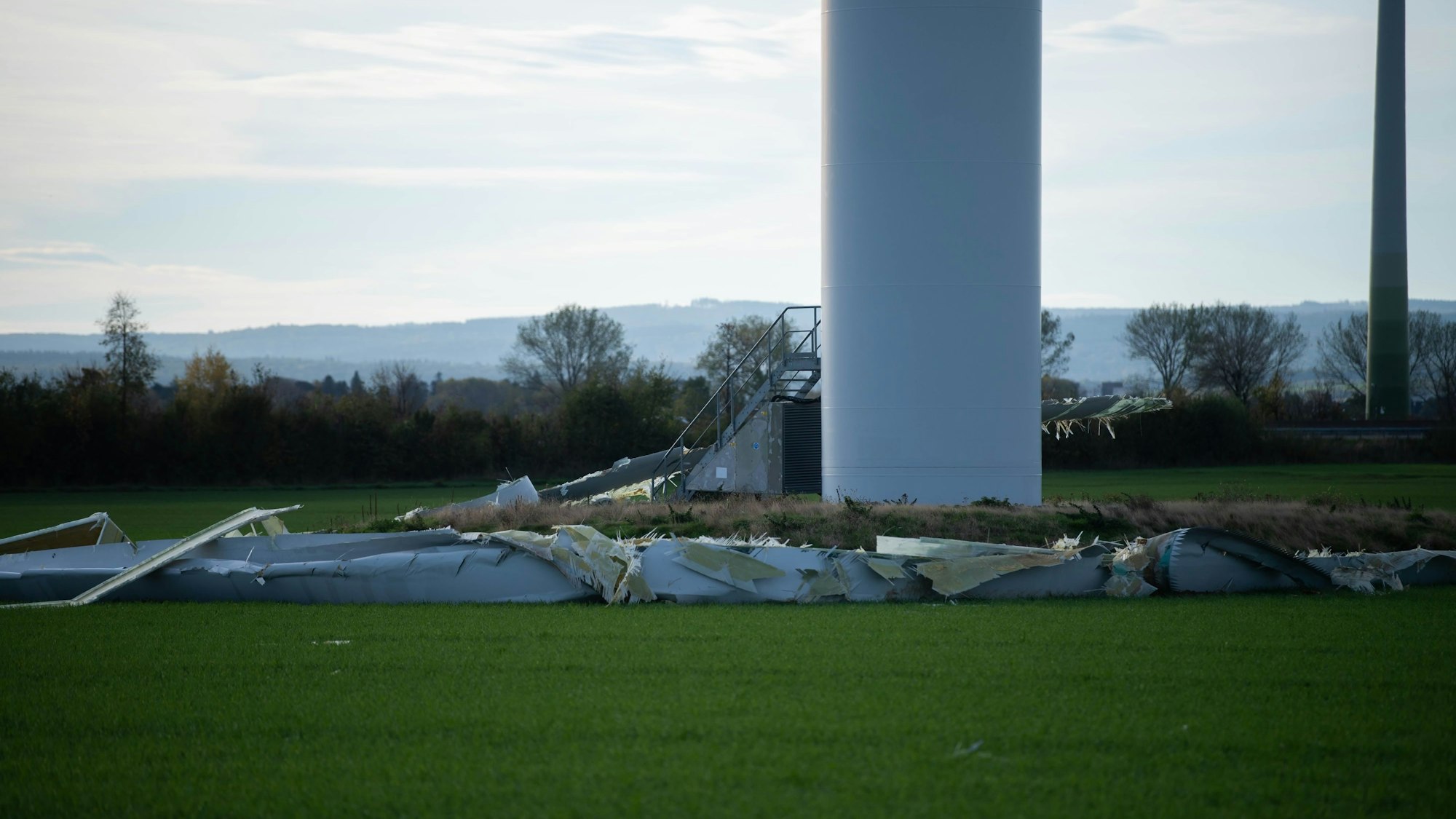 Auf dem Boden liegen die zerstörten Reste eines Flügels auf einer Wiese.
