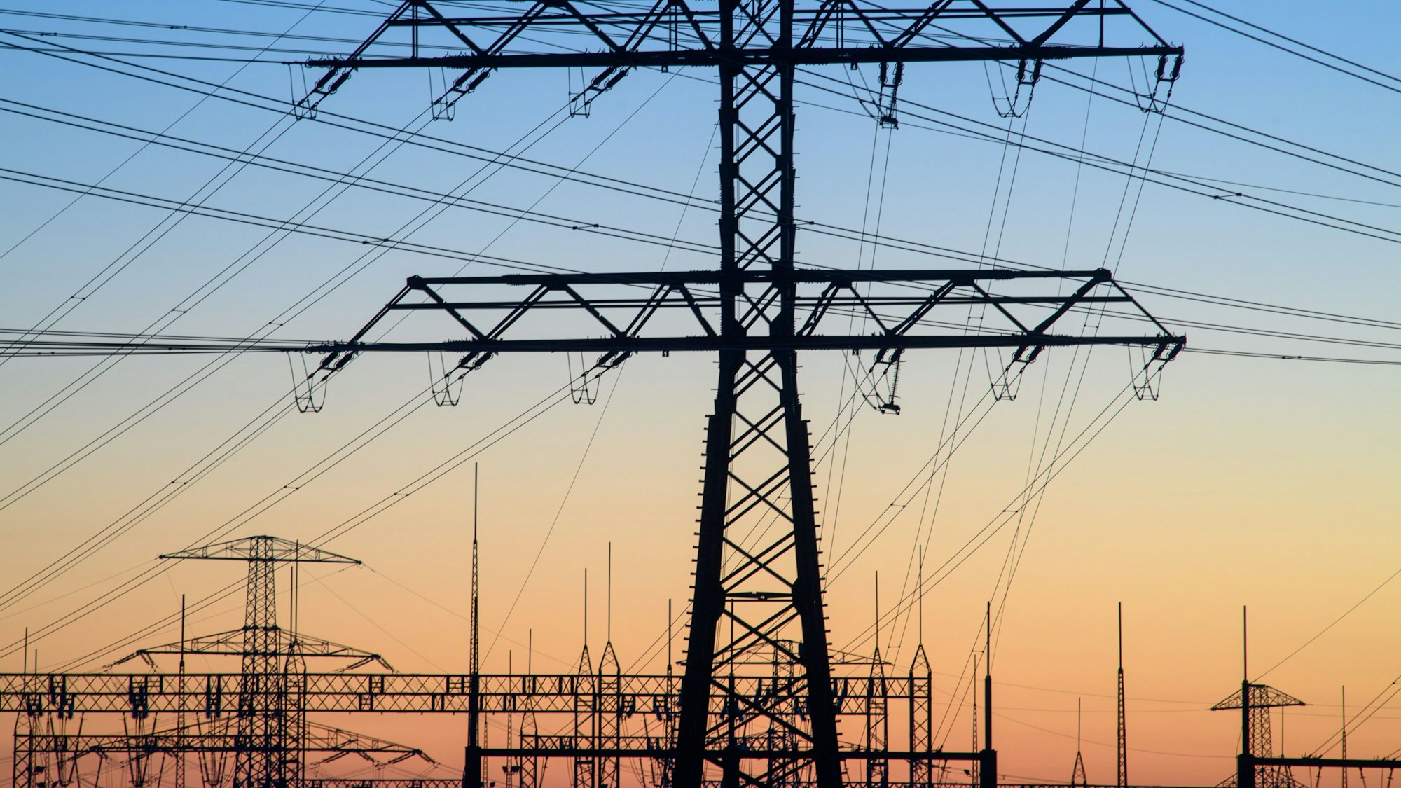 Das Bild zeigt die technischen Anlagen und Stromleitungen eines Umspannwerks.