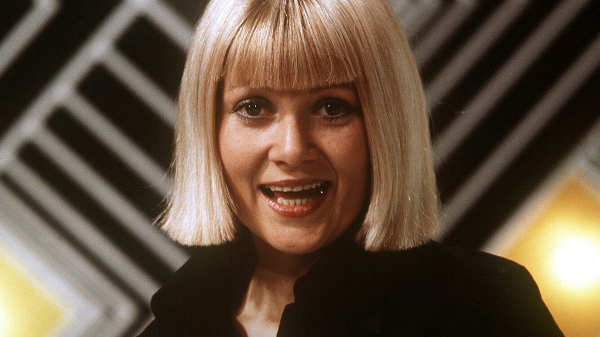 Die dänische Schlagersängerin Gitte Haenning mit 70s-Frisur bei einem Auftritt in jenem Jahrzehnt. Sie hat den Mund zum Singen geöffnet. Sie trägt eine schwarze Bluse.