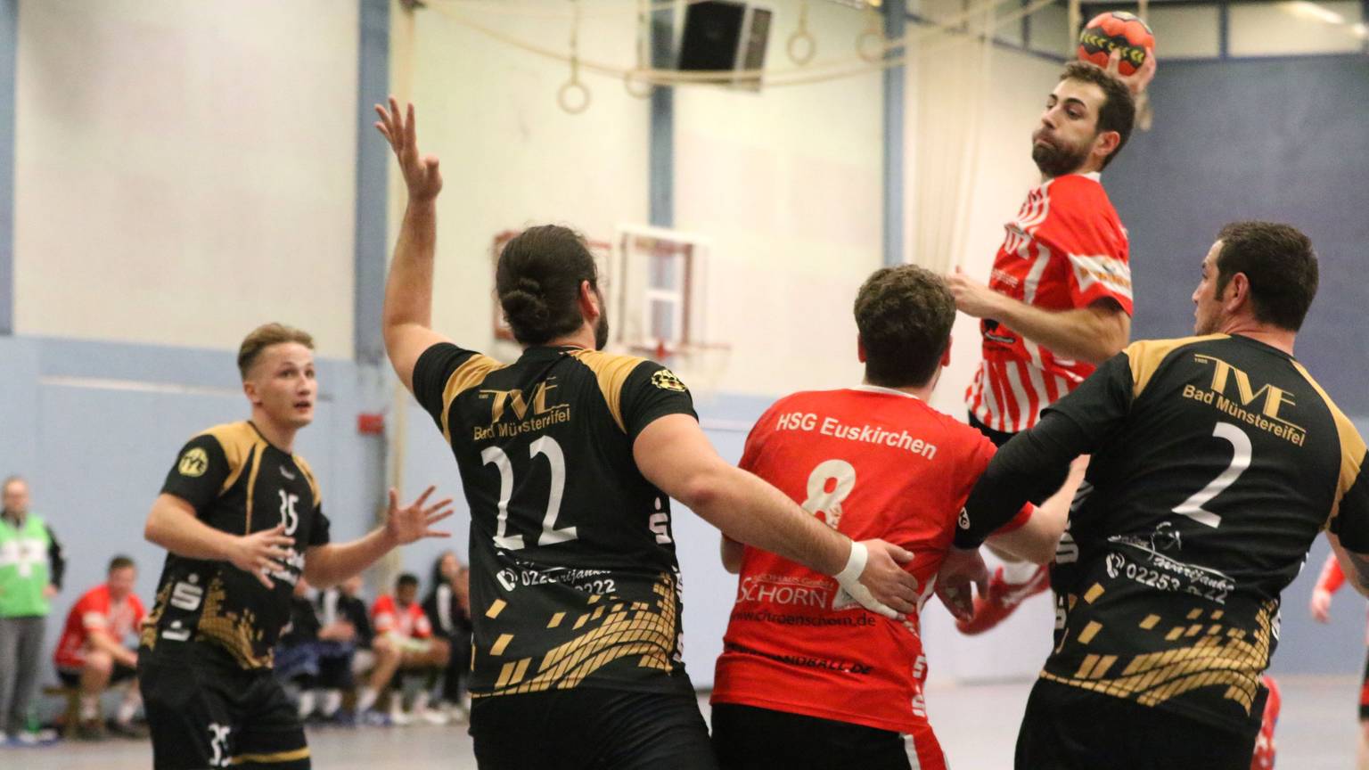 Ein Handballer wirft umringt von Gegenspielern seinen Ball.