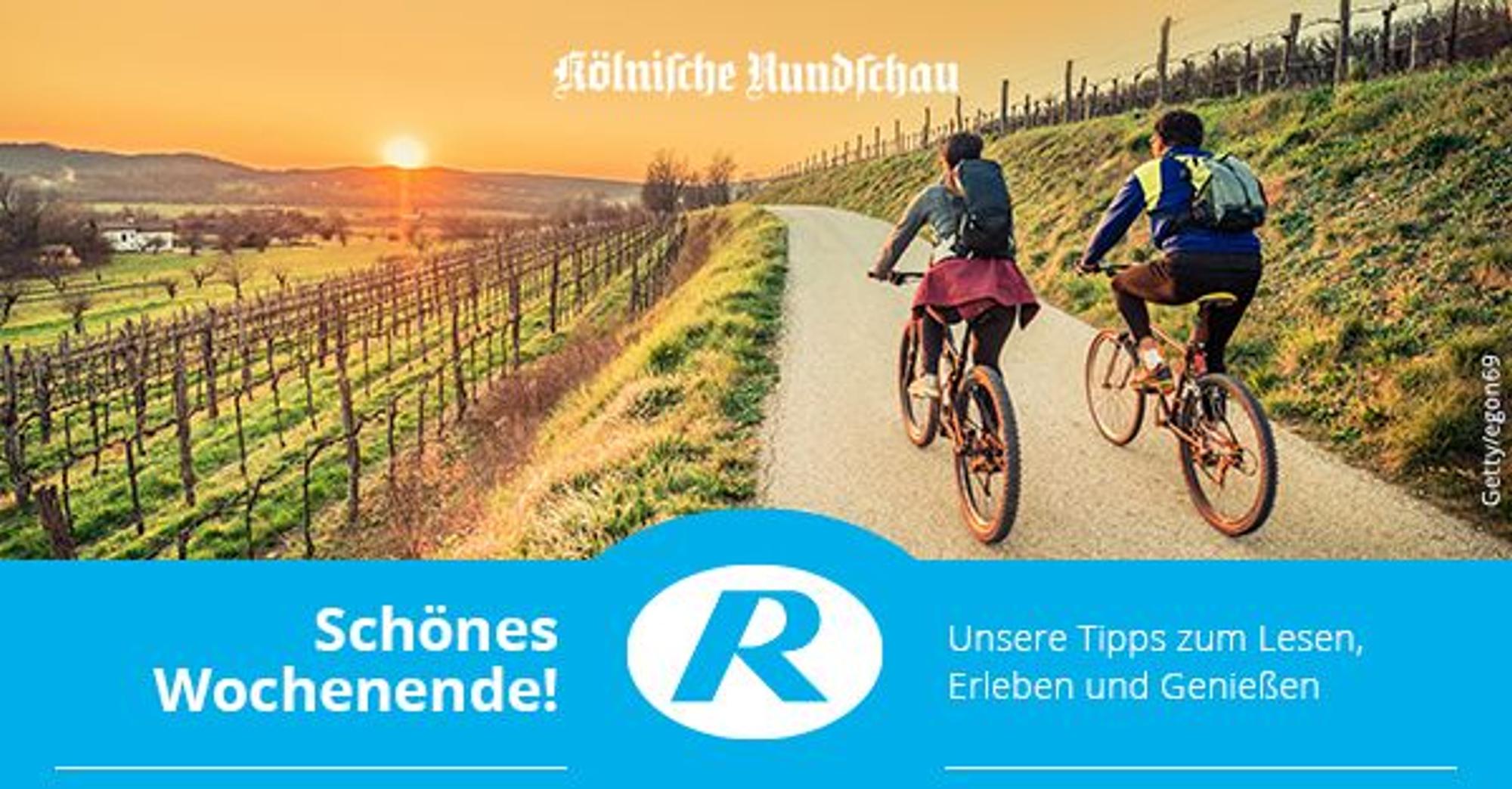 Zwei Menschen sind mit dem Fahrrad in Weinbergen unterwegs.
