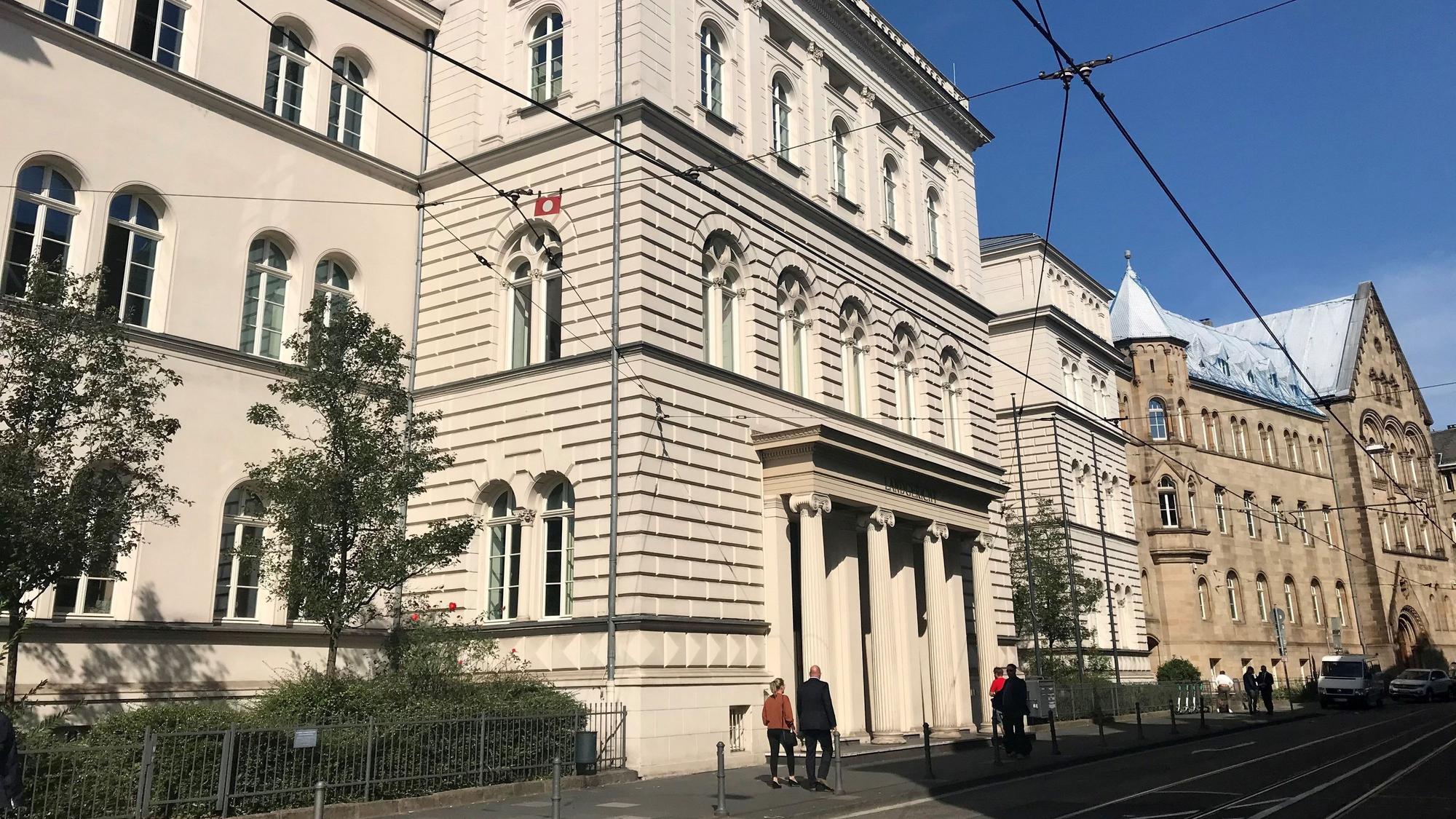 Das Gebäude des Landgerichts Bonn, Menschen gehen auf dem Bürgersteig davor.