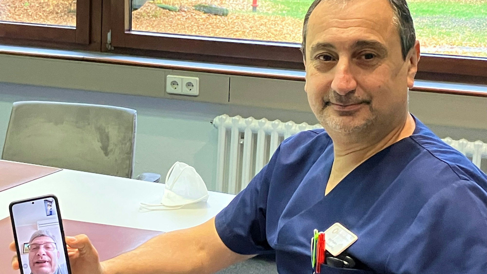 Der Psychiater Igor Prudkov telefoniert mit seinem Freund Dr. Vitaliy P. in Charkiw. Dieser ist auf dem Handybildschirm zu sehen, den Prudkov in der Hand hält.