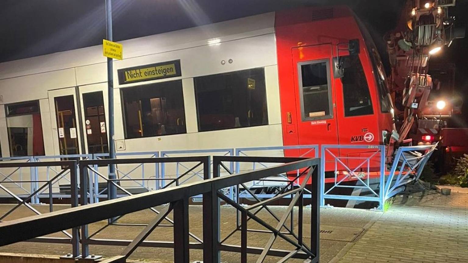 Eine Straßenbahn, die an einer Endhaltestelle gegen den Prellbock gefahren ist und die Bahnsteigbegrenzung durchbricht.