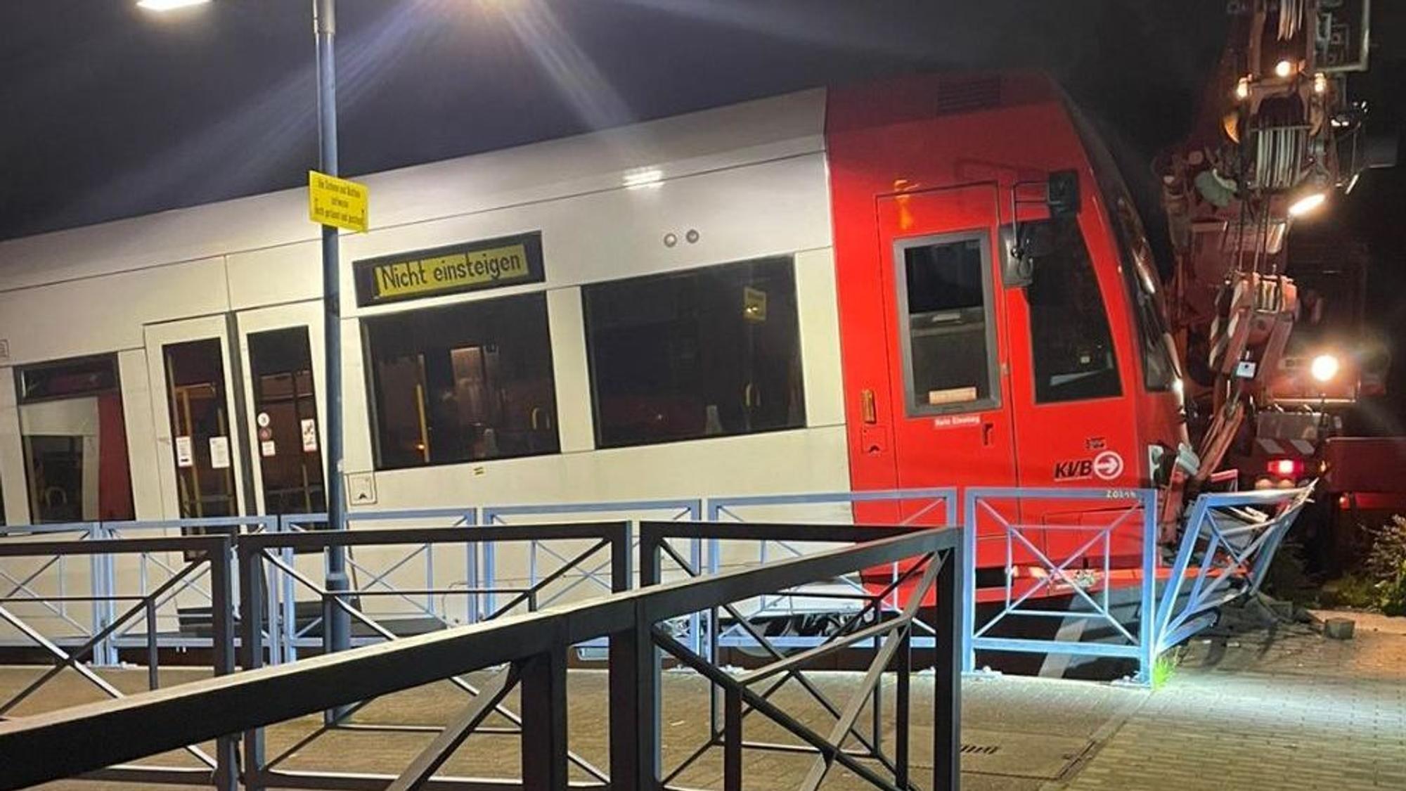 Eine Straßenbahn, die an einer Endhaltestelle gegen den Prellbock gefahren ist und die Bahnsteigbegrenzung durchbricht.