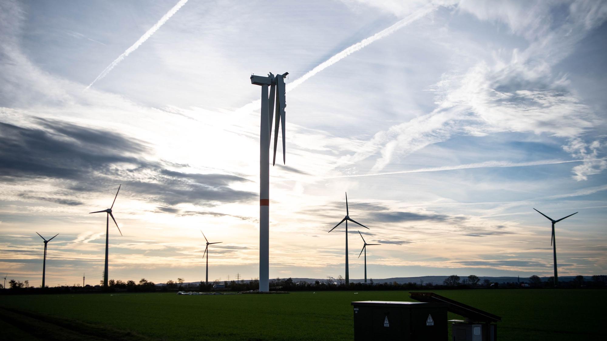 Auf einem Feld bei Zülpich stehen sieben Windräder. Bei dem vordersten fehlt ein Flügel, ein zweiter hängt nur noch in Teilen am Korpus.