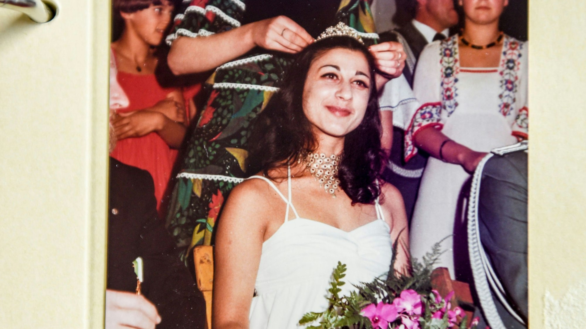 Shuli Grohmann trägt ein weißes Kleid und bekommt ein Diadem aufgesetzt, als sie Schützenkönigin in Grevenbroich wird.