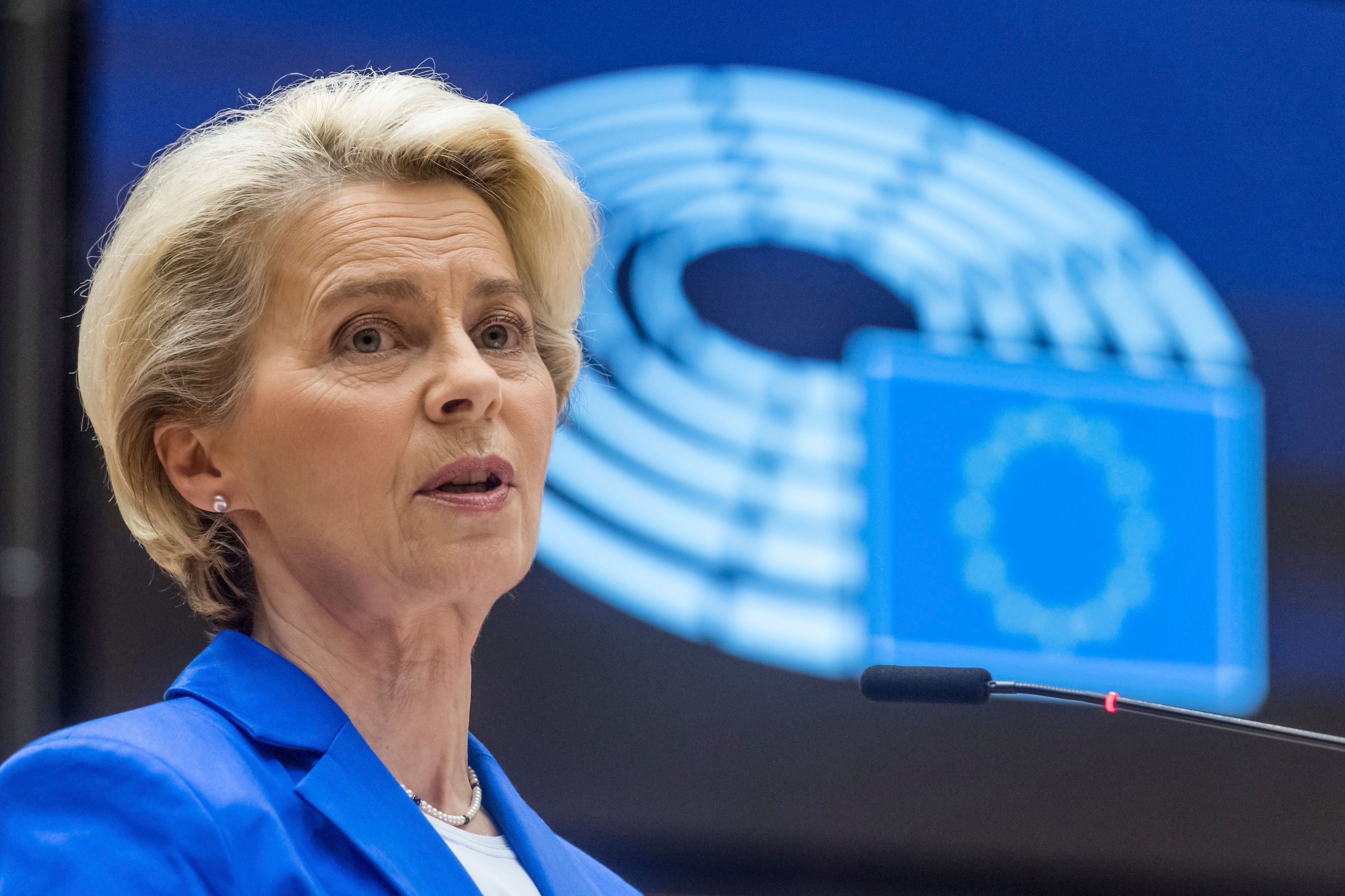 Ursula von Leyen im Europaparlament. Sie schaut ernst und hinter ihr ist die EU-Flagge zu sehen.