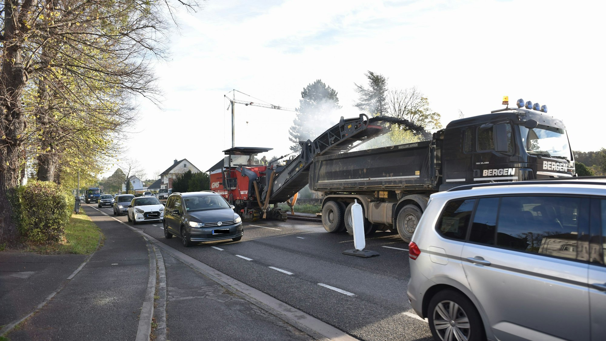 Viele Autos fahren dicht an den Baustellenfahrzeugen auf der B266 vorbei.