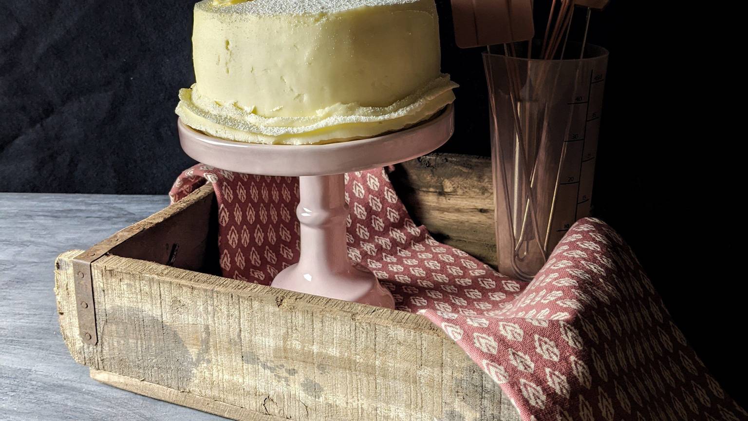 Zum Themendienst-Bericht von Doreen Hassek vom 9. November 2022: Die mit Buttercreme eingestrichene Weihnachtstorte bekommt als Deko einen Spekulatius und zwei Rosmarinzweige und sieht damit wie eine Winterlandschaft aus.