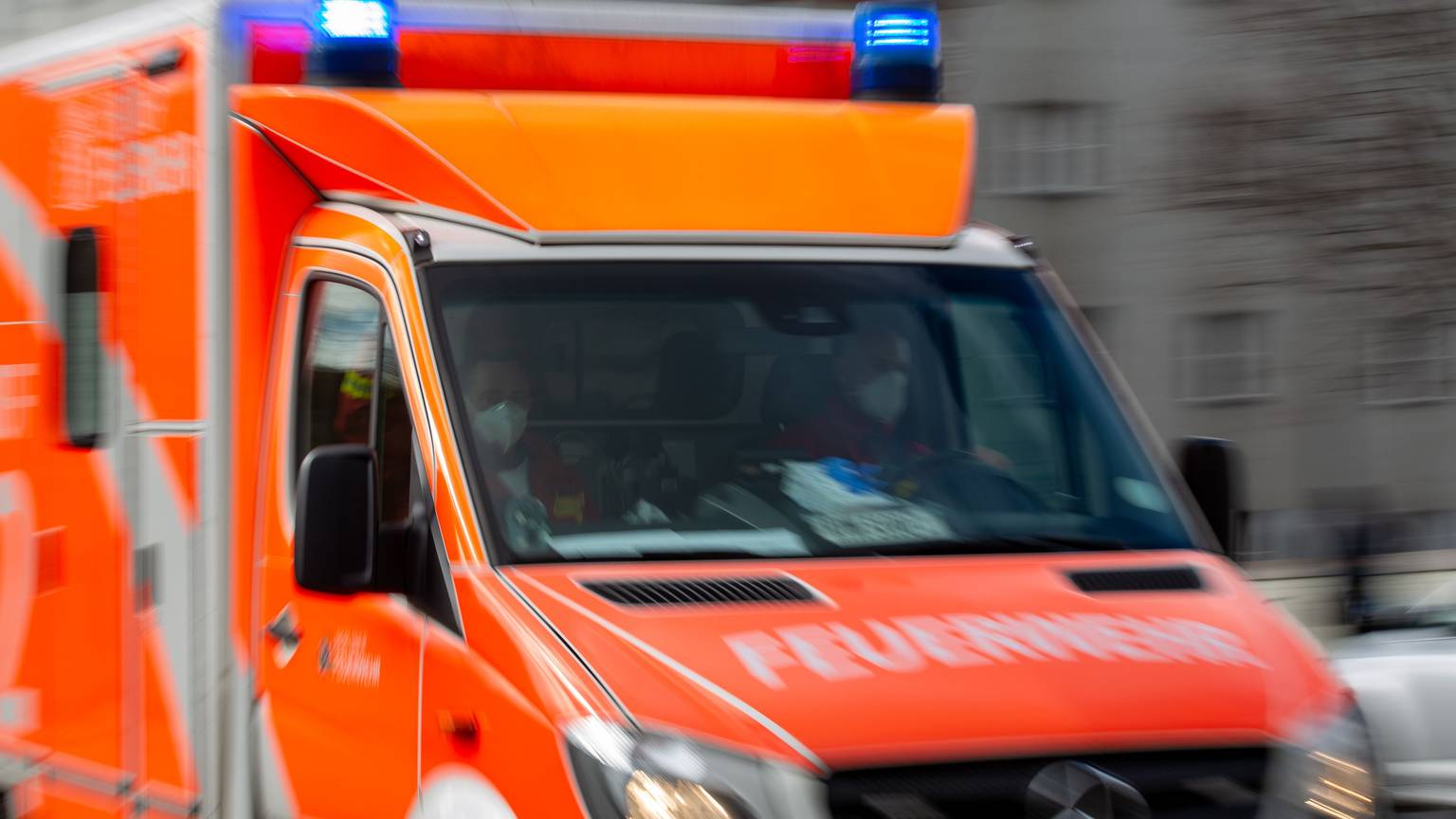 Ein Rettungswagen der Feuerwehr fährt auf einer Straße.