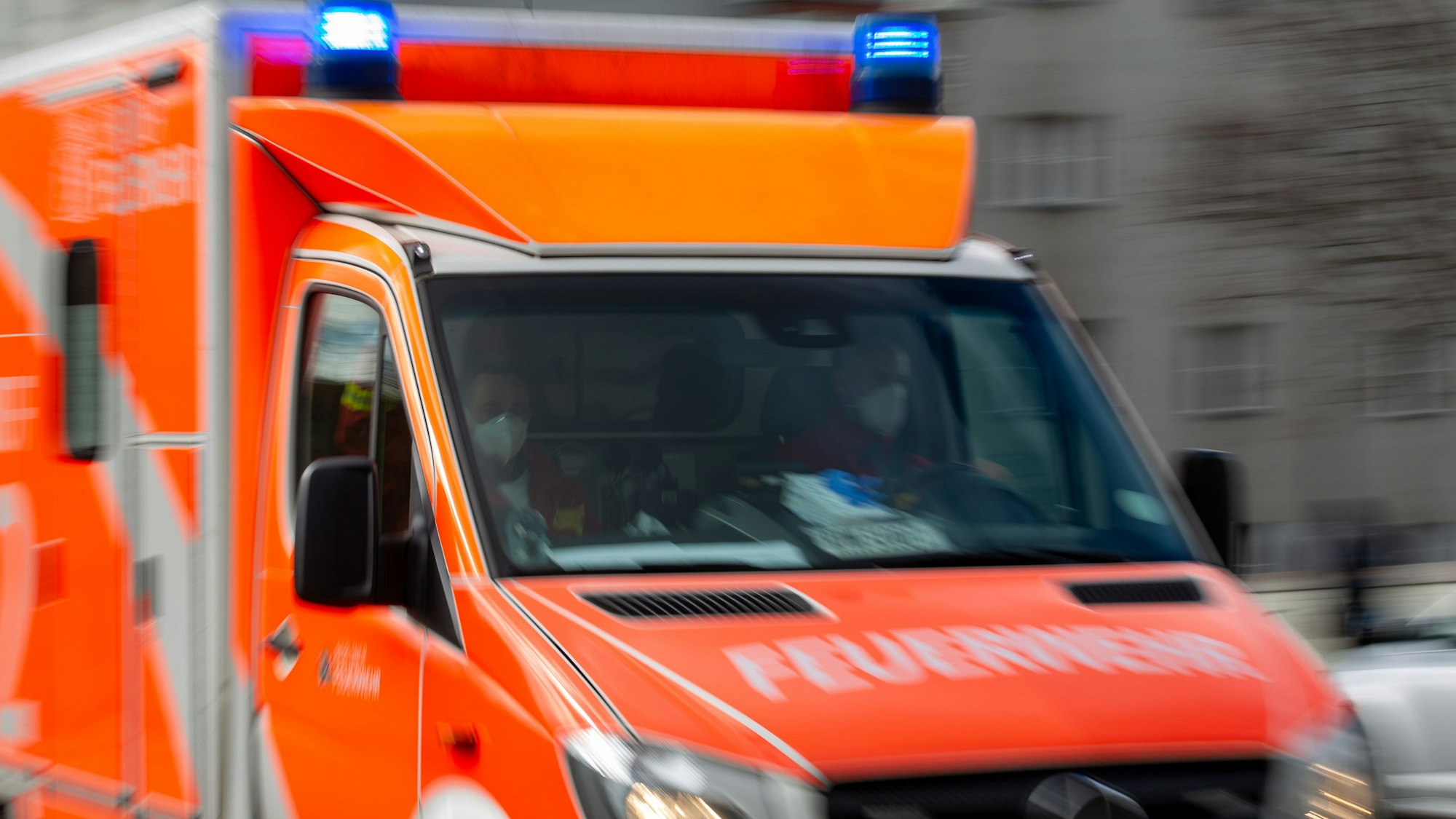 Ein Rettungswagen der Feuerwehr fährt auf einer Straße.