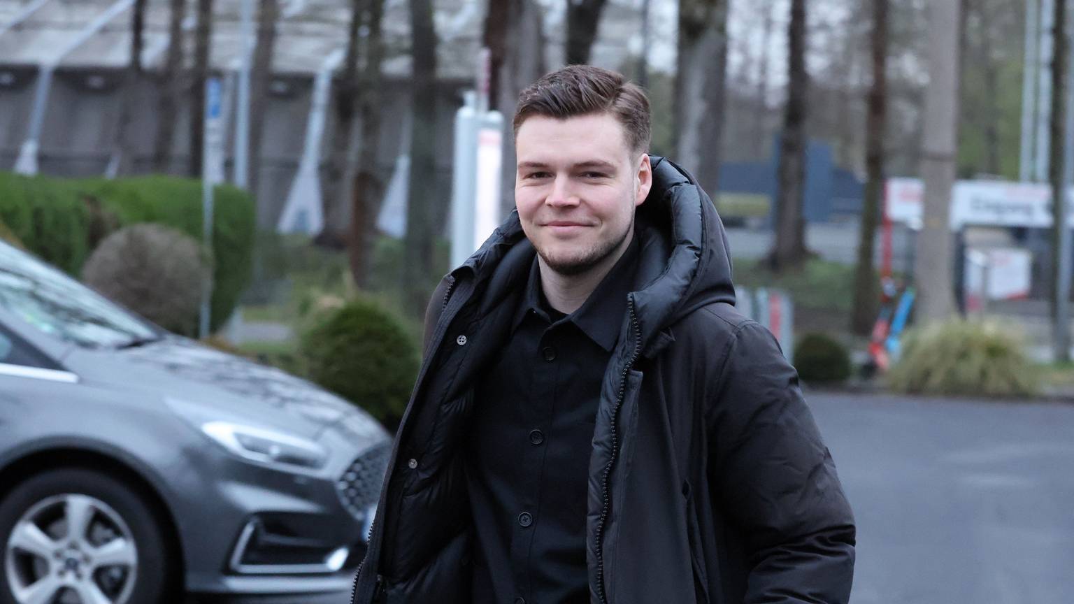 Lukas Berg schaut lächelnd in die Kamera.