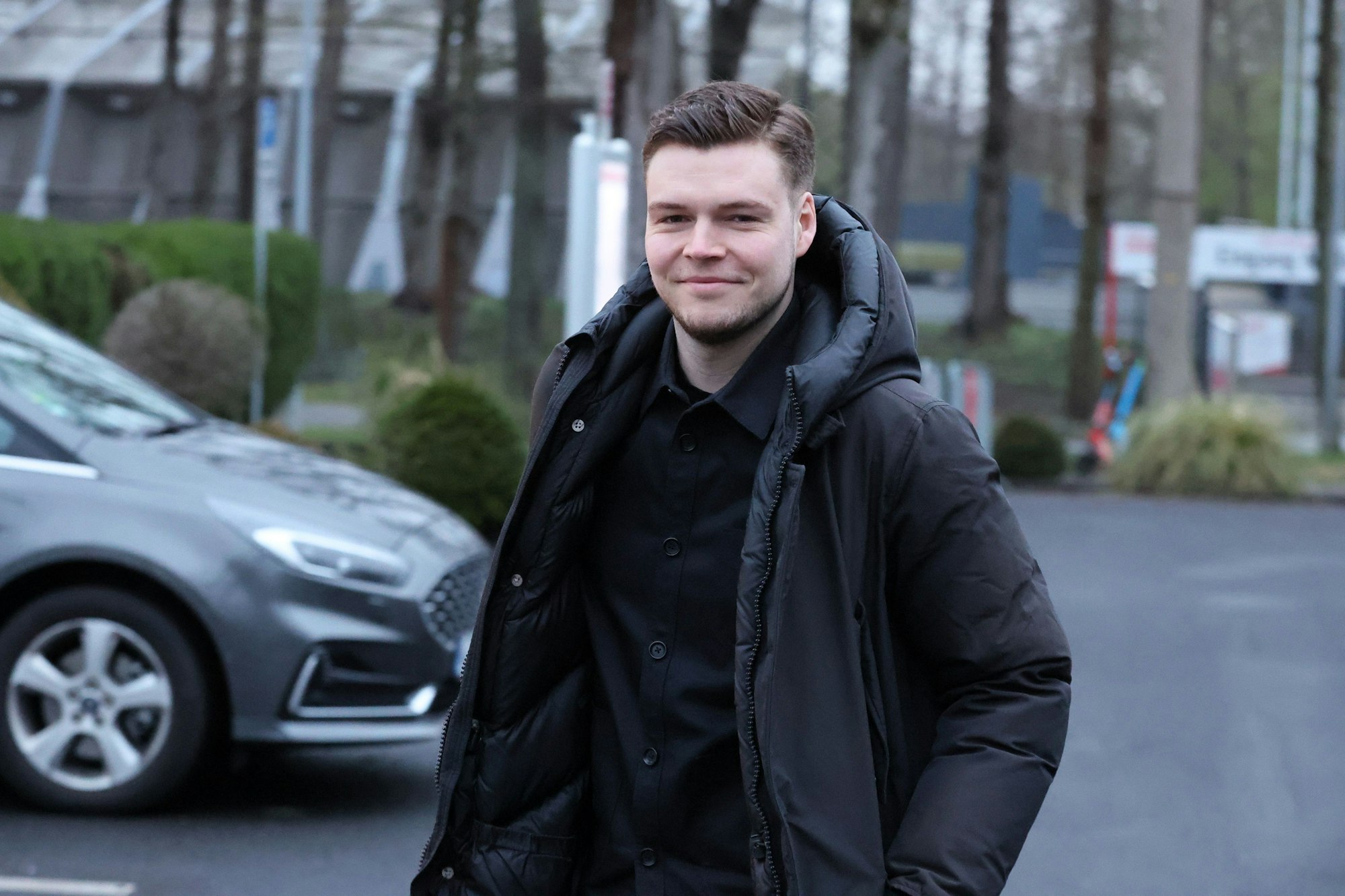 Lukas Berg schaut lächelnd in die Kamera.