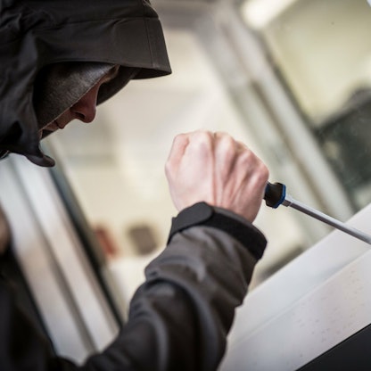 Ein Mann mit einem Werkzeug an einem Fenster.