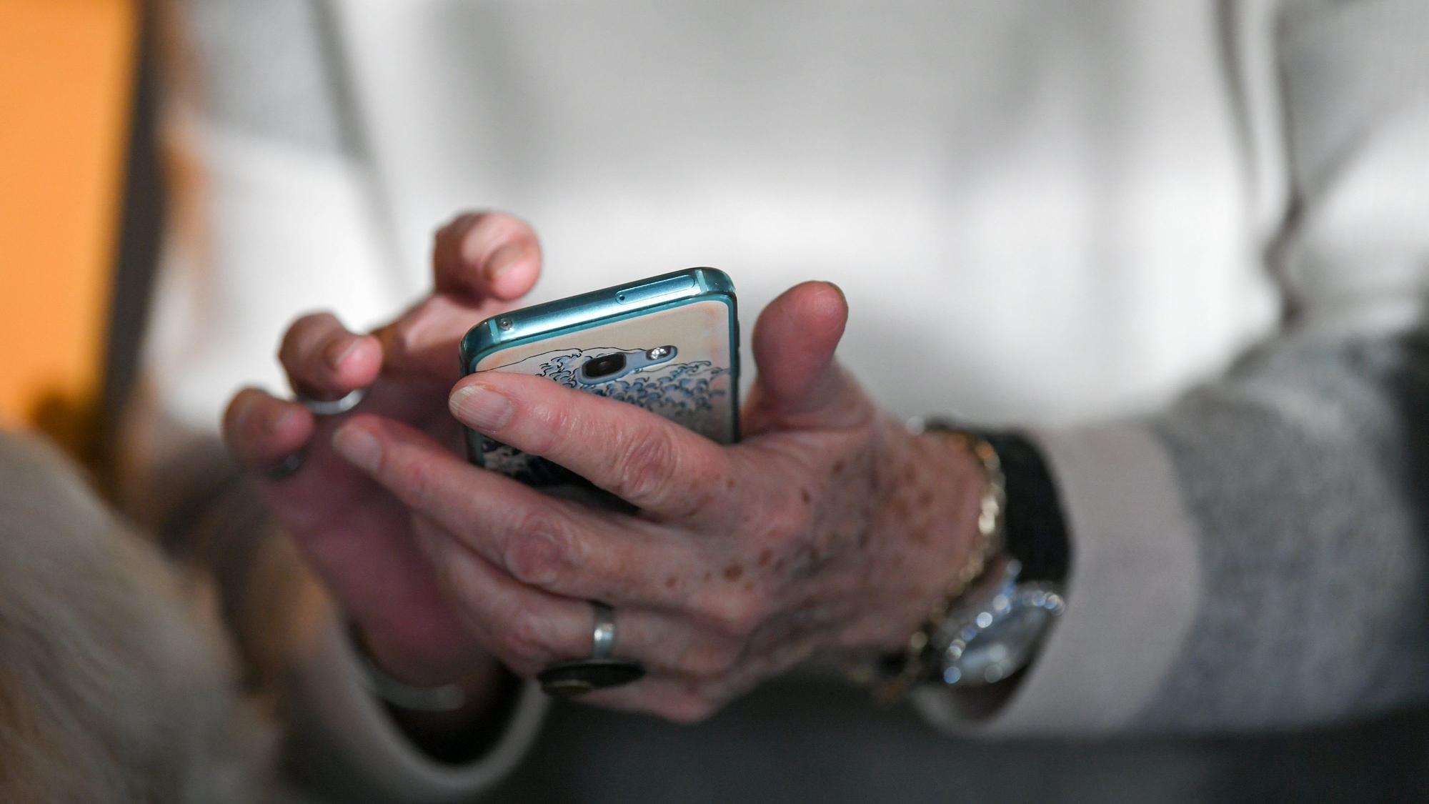 Eine Seniorin hält am 4.12.2019 ihr Smartphone in den Händen.