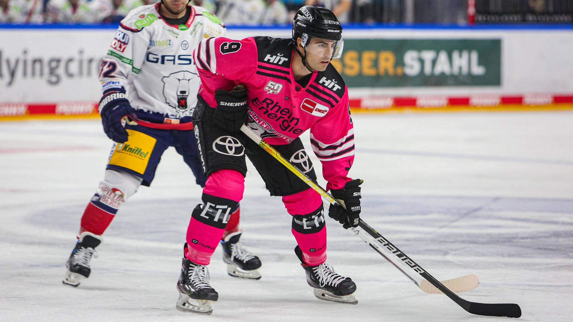 Maximilian Kammerer, rechts im rosafarbenen Trikot läuft mit Schläger auf der Eisfläche. Der Stürmer hat seinen Vertrag bei den Kölner Haien um zwei Jahre verlängert.