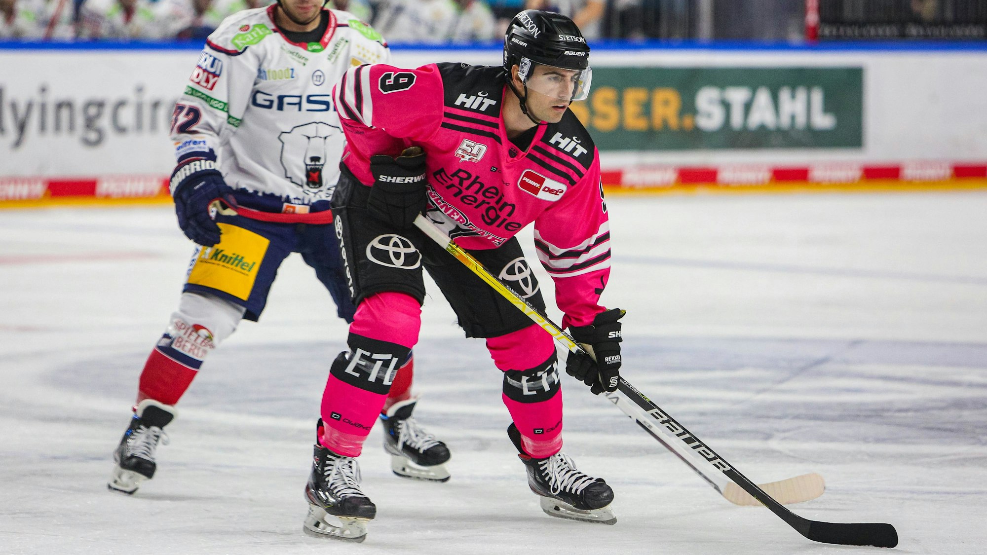 Maximilian Kammerer, rechts im rosafarbenen Trikot läuft mit Schläger auf der Eisfläche. Der Stürmer hat seinen Vertrag bei den Kölner Haien um zwei Jahre verlängert.