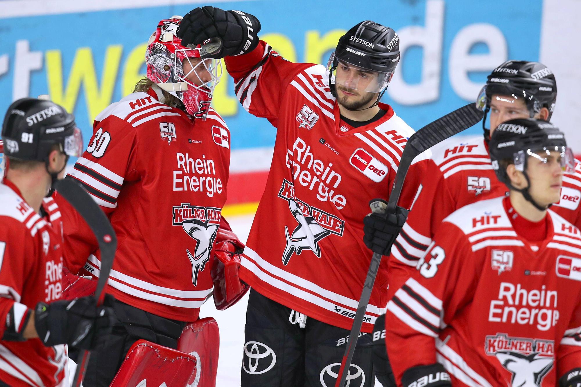Haie-Verteidiger Maximilian Glötzl (Mitte) steht rechts neben Torwart Mirko Pantkowski und gratuliert seinem Teamkollegen zur Leistung. Glötzl hat seinen Vertrag beim KEC bis 2024 verlängert.