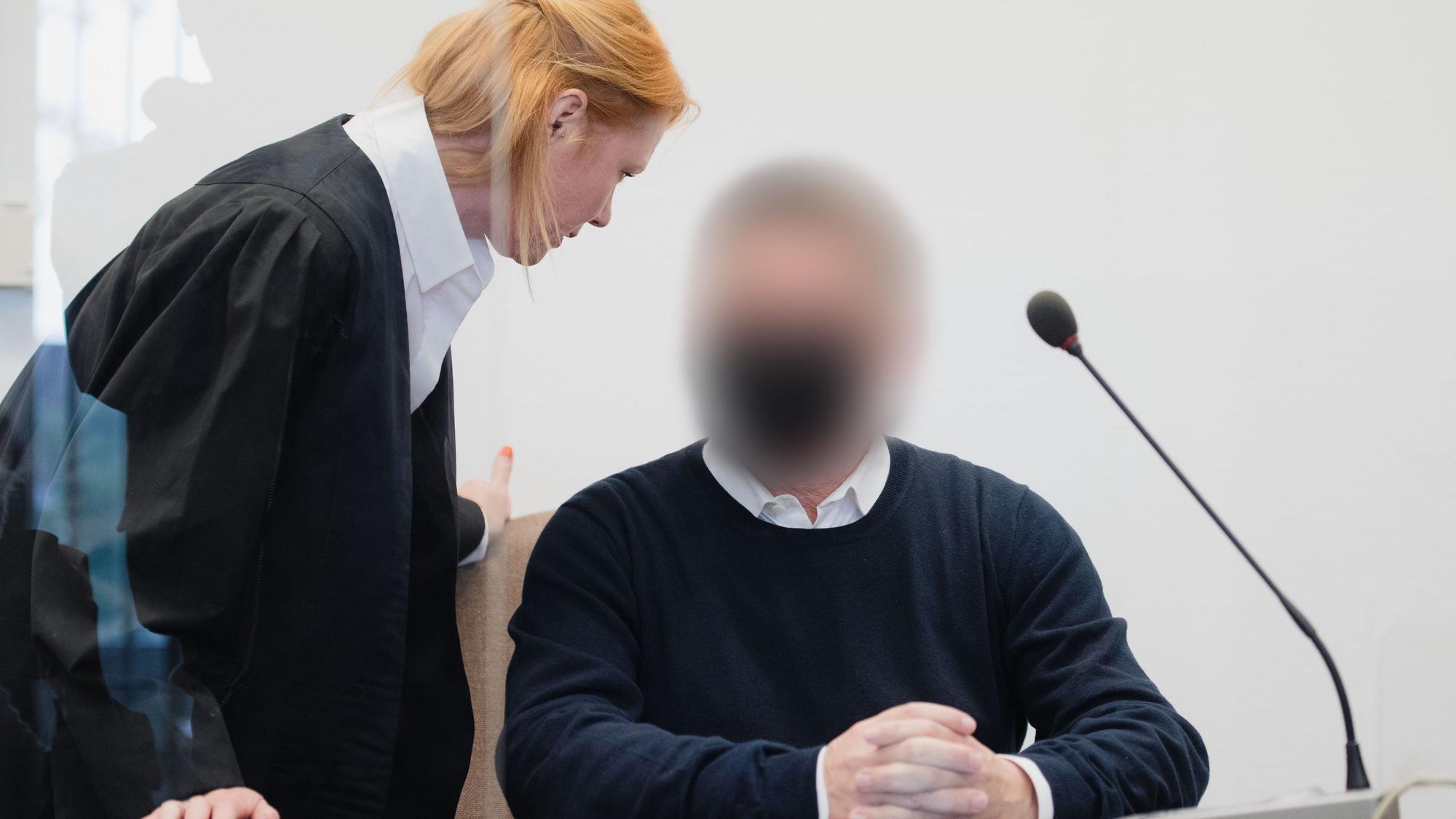 Zu sehen ist: Ein angeklagter Fotograf sitzt im Landgericht auf der Anklagebank und spricht mit seiner Verteidigerin Denise Gerull. Die Staatsanwaltschaft wirft dem Mann vor, mehreren Kinder-Models sexuelle Gewalt angetan zu haben.