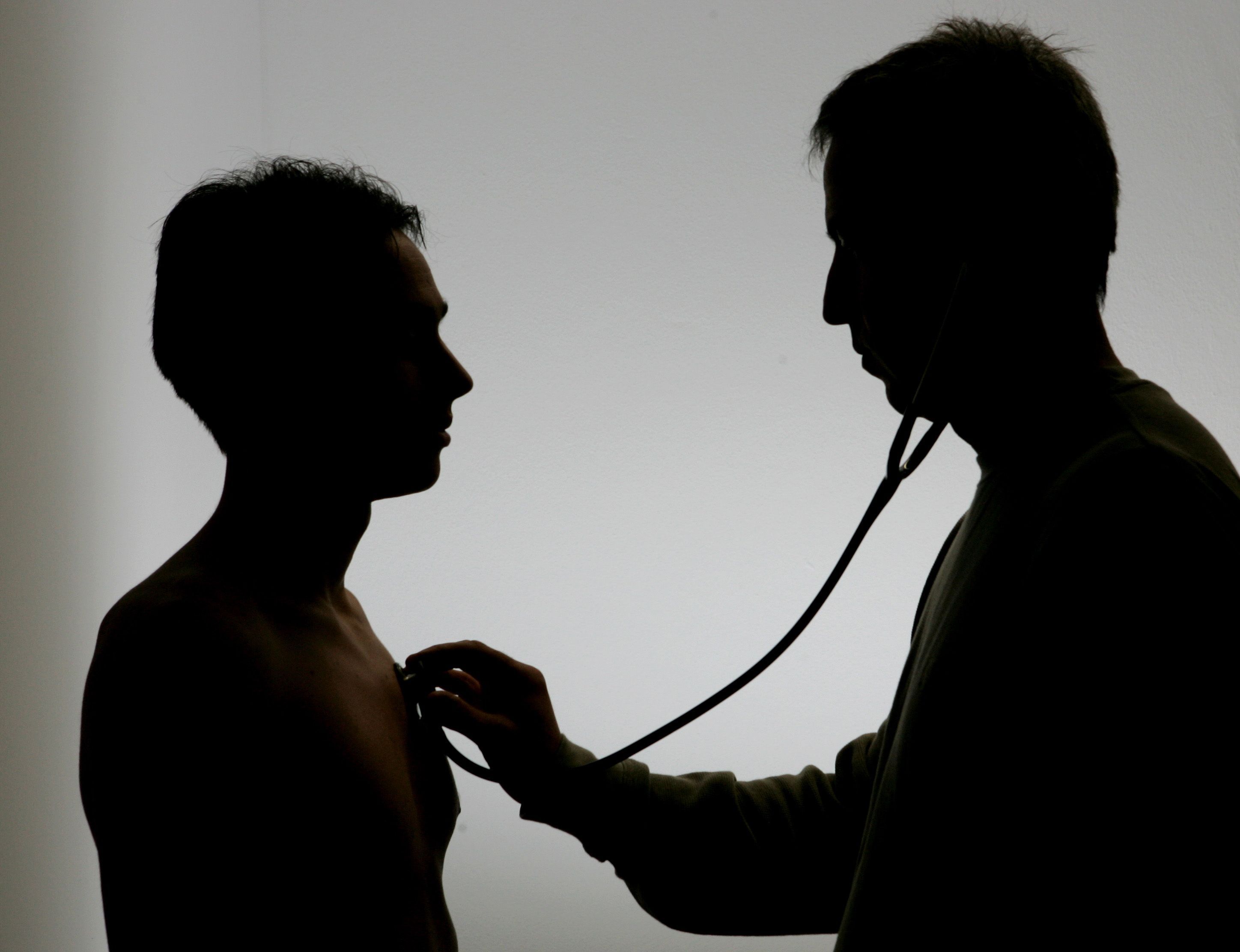 Ein Arzt untersucht einen Patienten mit einem Stethoskop.