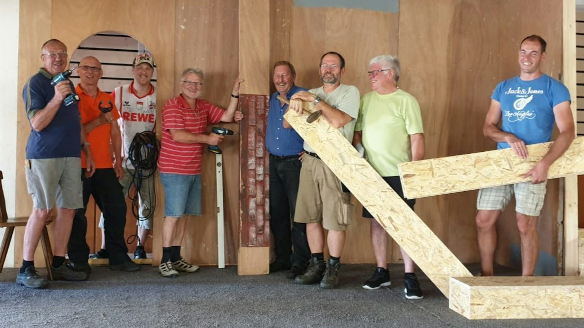 Swisttal-Odendorf: Acht Männer mit Handwerkszeug und Holzelementen arbeiten an einem Bühnenaufbau für die örtliche Theatergruppe.