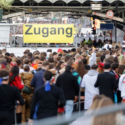 Hunderte junge Menschen drängen sich vor dem Eingang zur Zülpicher Straße im Straßenkarneval in der Kölner Innenstadt.