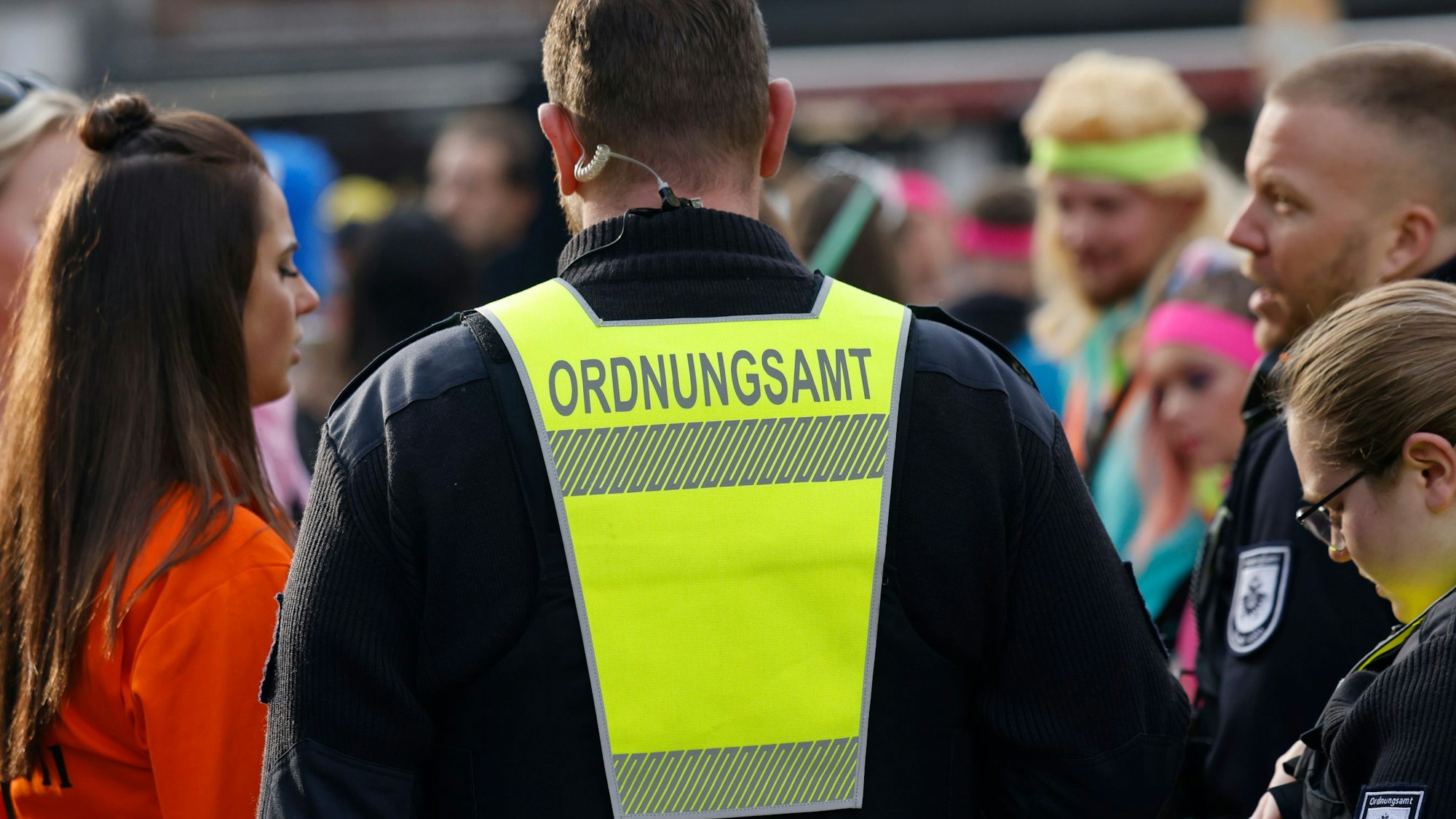 Zwei Mitarbeiter des Ordnungsamts im Gespräch mit Feiernden.