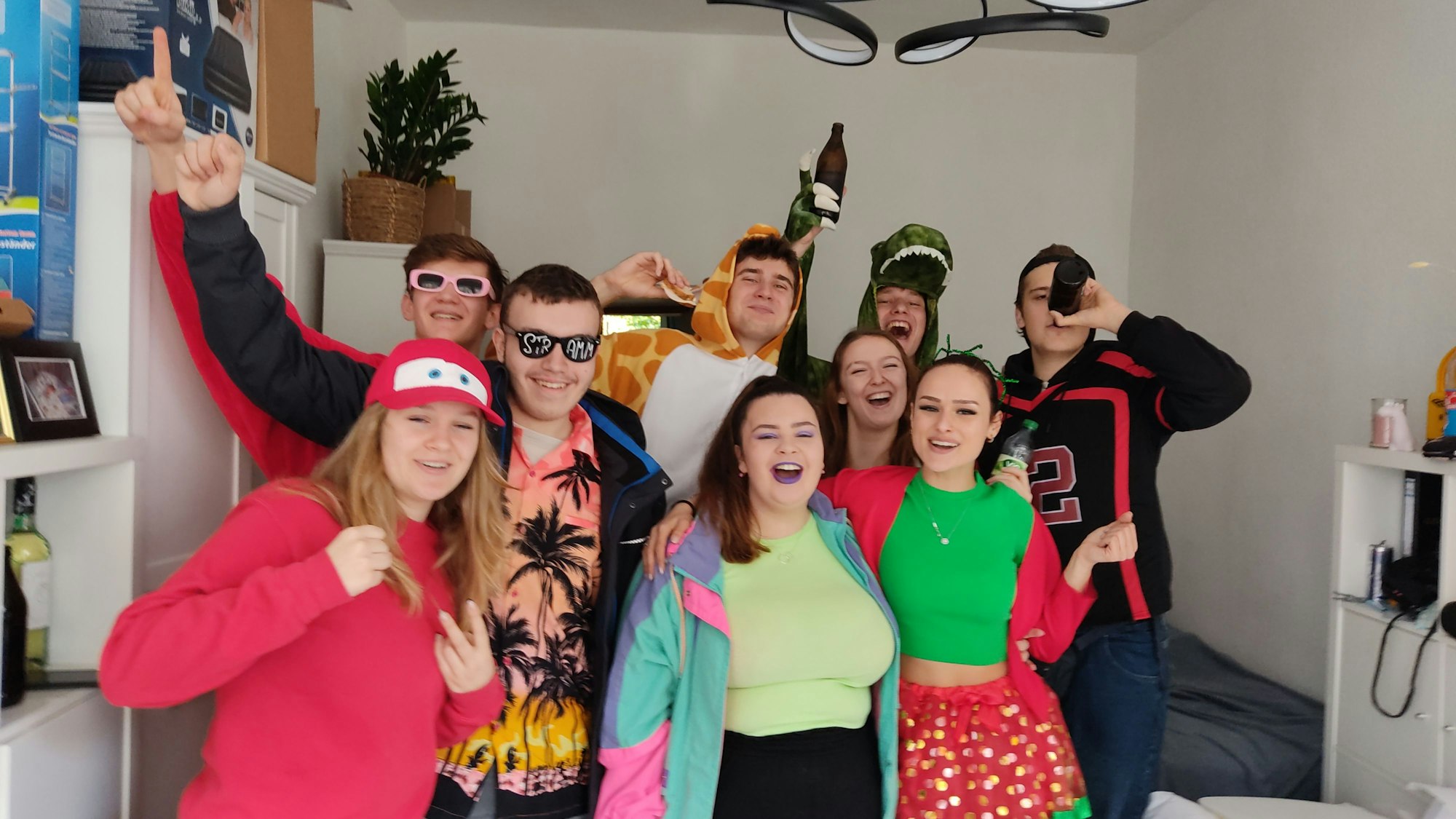 Mehrere junge Menschen in einem Zimmer posieren fröhlich für das Foto.