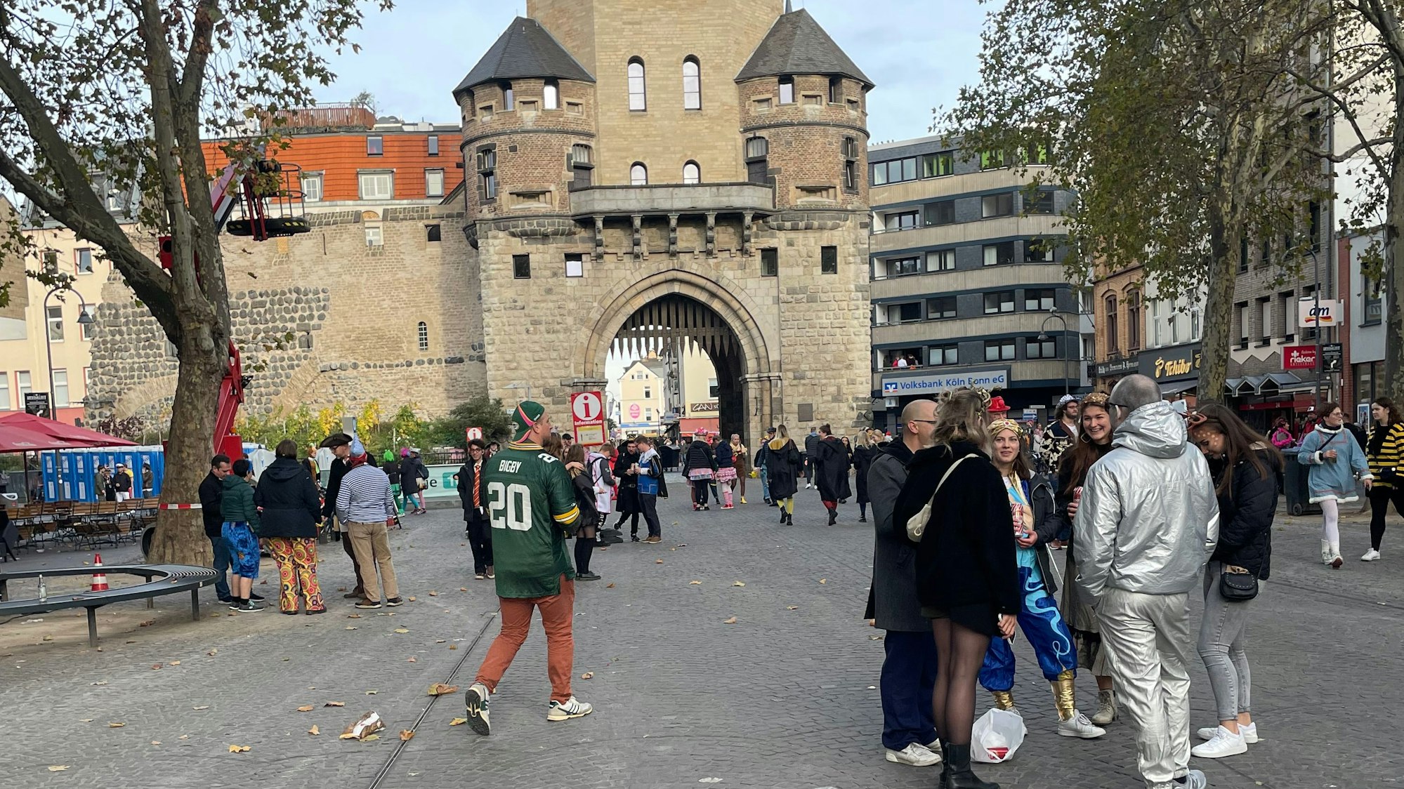 Chlodwigplatz in Köln, im Hintergrund Severinstorburg, im Vordergrund verkleidete Menschen.