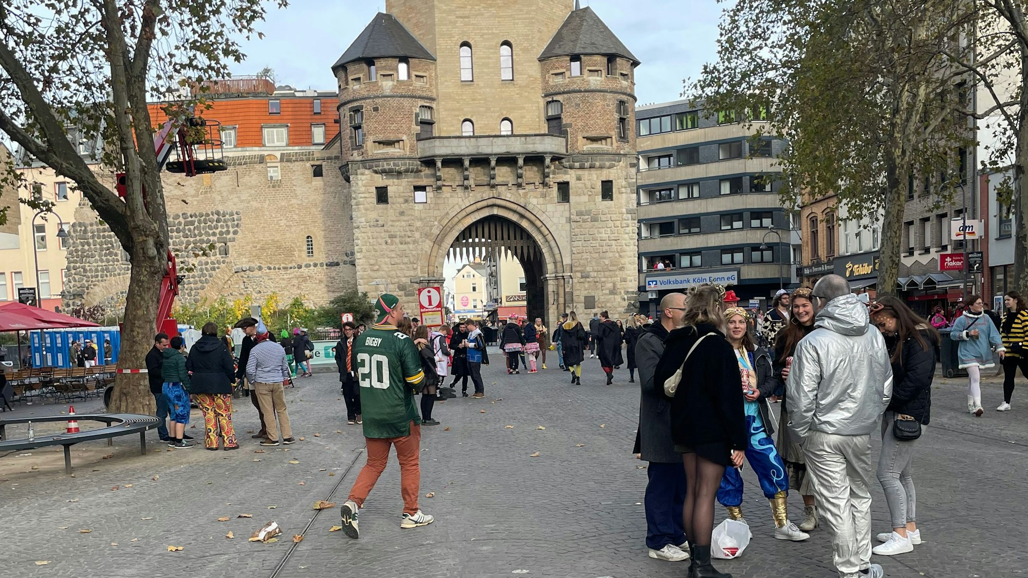 Chlodwigplatz in Köln, im Hintergrund Severinstorburg, im Vordergrund verkleidete Menschen.