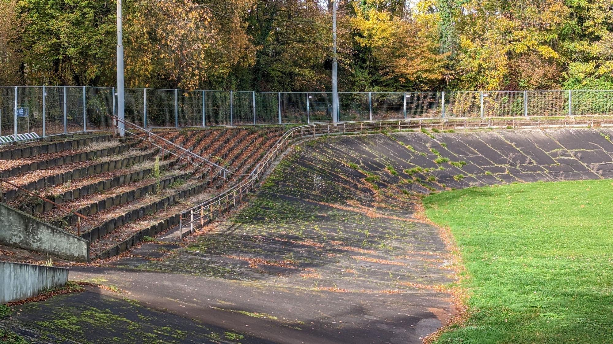 Die Radrennbahn am Stadion Alt-Hürth an der Dunantstraße: Ränge, Stufen und Bahn sind in schlechtem Zustand und mit Gras bewachsen.