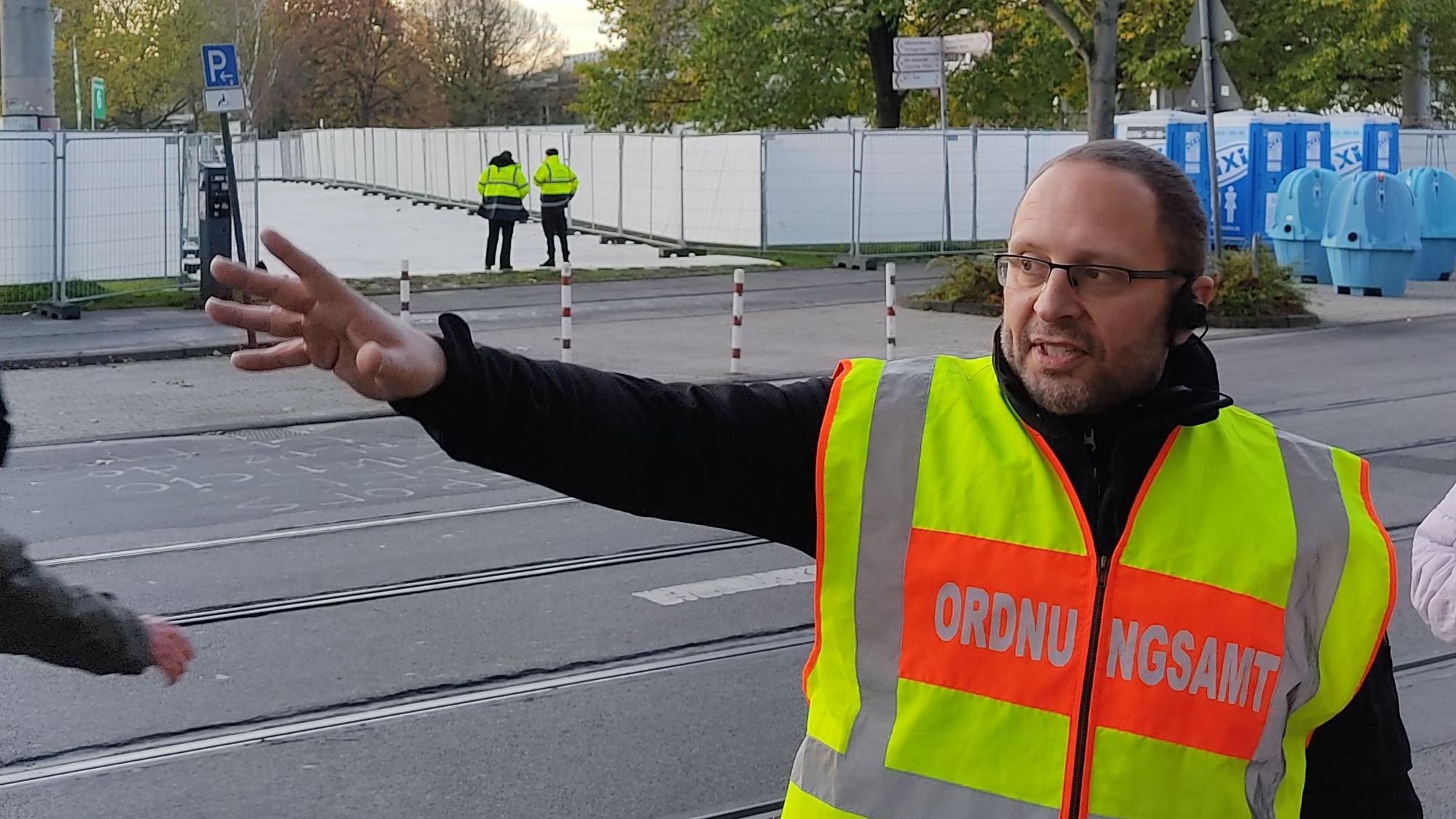 Ein Ordnungsamtsmitarbeiter in einer neongelben Weste mit der Aufschrift „Ordnungsamt“.