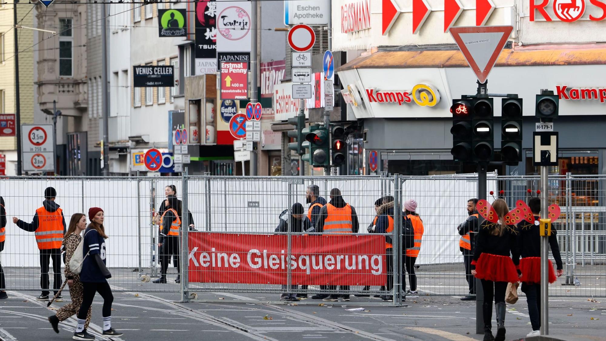 Eine Absperrung auf der Straße, an dem ein Plakat hängt: „Keine Gleisquerung“.