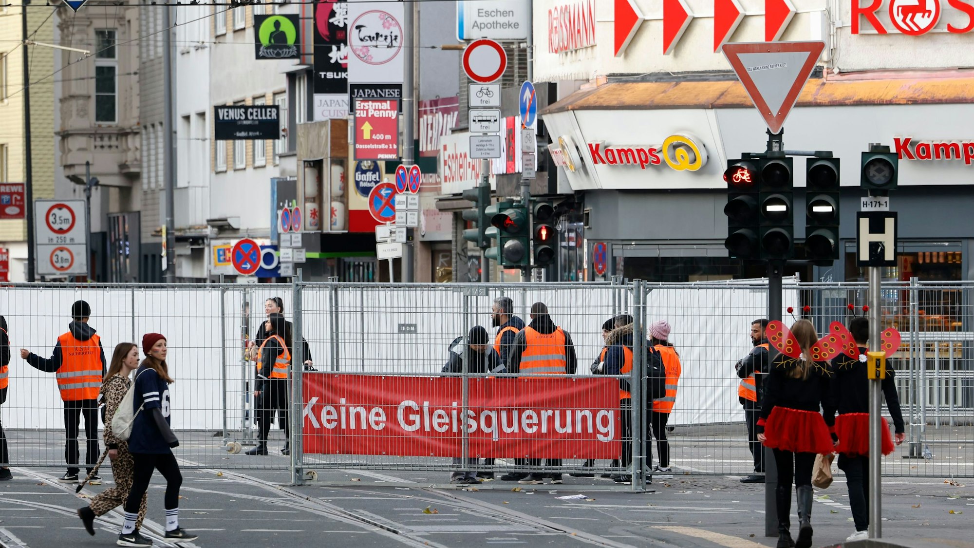 Eine Absperrung auf der Straße, an dem ein Plakat hängt: „Keine Gleisquerung“.