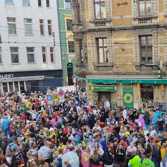 Die Gaststätte Oma Kleinmann am Elften Elften umringt von einer Menschenmasse aus verkleideten Feiernden.