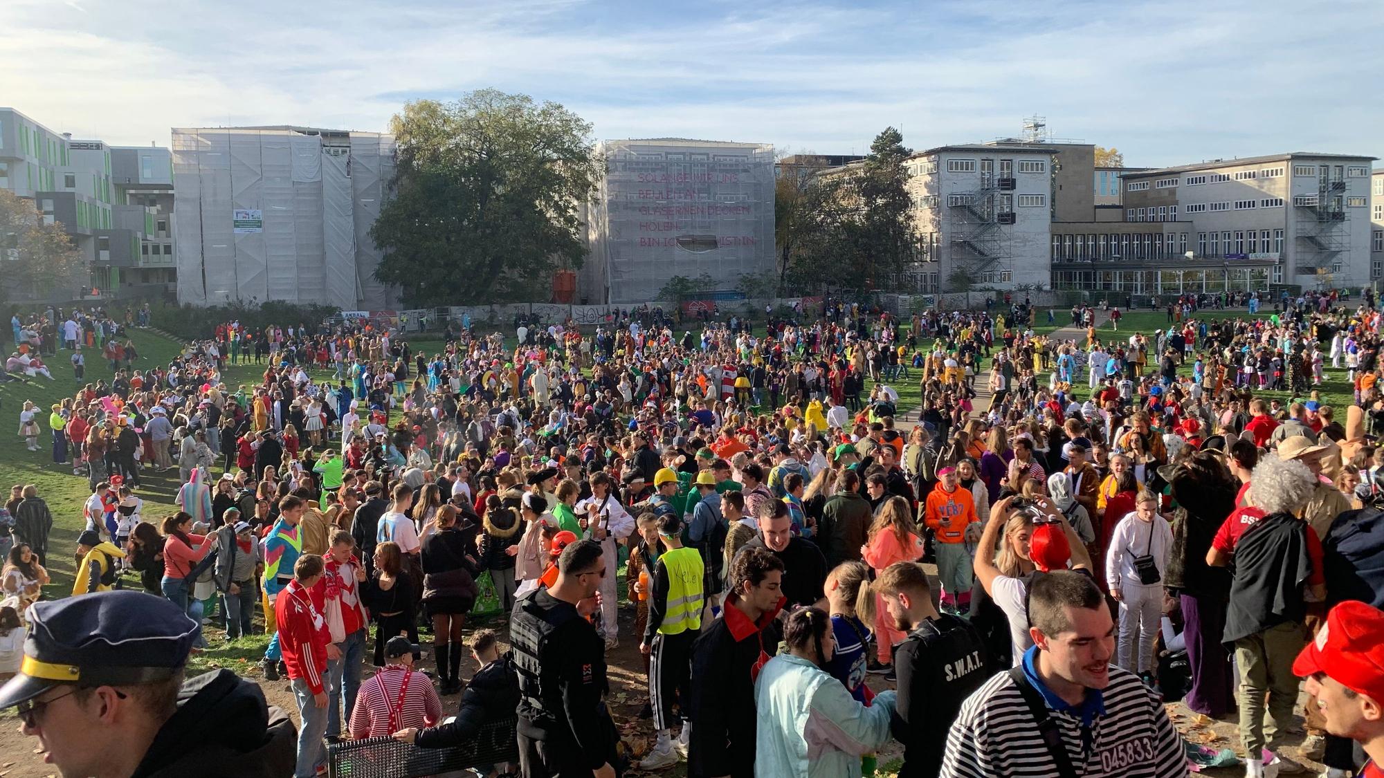 Hunderte junge Menschen drängen sich auf der Kölner Uniwiese. Diese wurde zur unkontrollierten Feierzone am Elften Elften in Köln, weil die Zülpicher Straße schon am Mittag überfüllt war.
