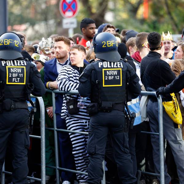 Karnevalisten stehen an einer Absperrung, da Polizeibeamte den Zugang zur Zülpicher Straße wegen Überfüllung abgeriegelt haben. Der Karnevalsauftakt zum 11.11. hat in Köln wie erwartet zu einem Massenandrang geführt