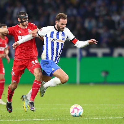 Lukas Tousart ist im Ballbesitz, Ellyes Skhiri kommt von hinten und will den Ball abnehmen. Im Hintergrund weitere Spieler.