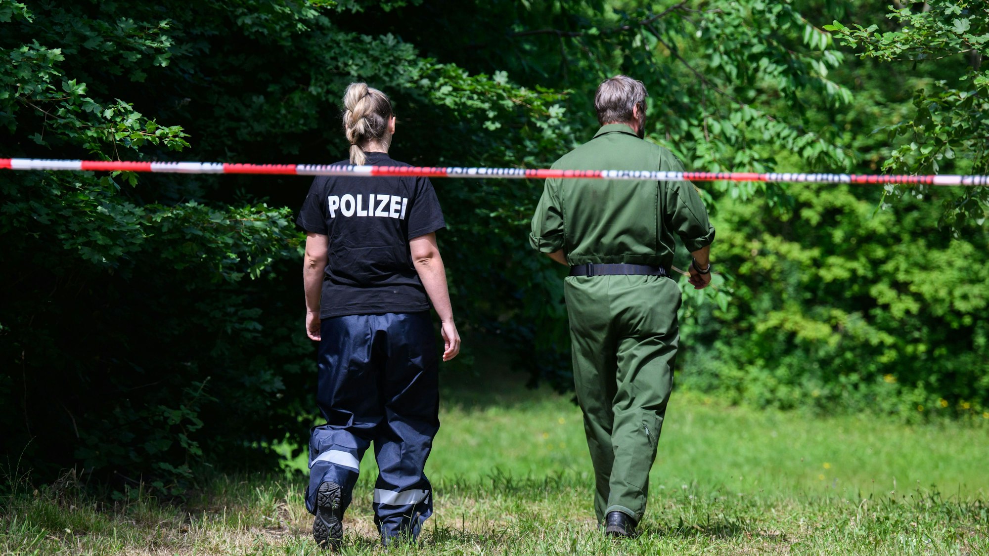 Mitarbeiter der Spurensicherung der Polizei Salzgitter stehen an einem Tatort an einer Grünfläche am Hans-Böckler-Ring.