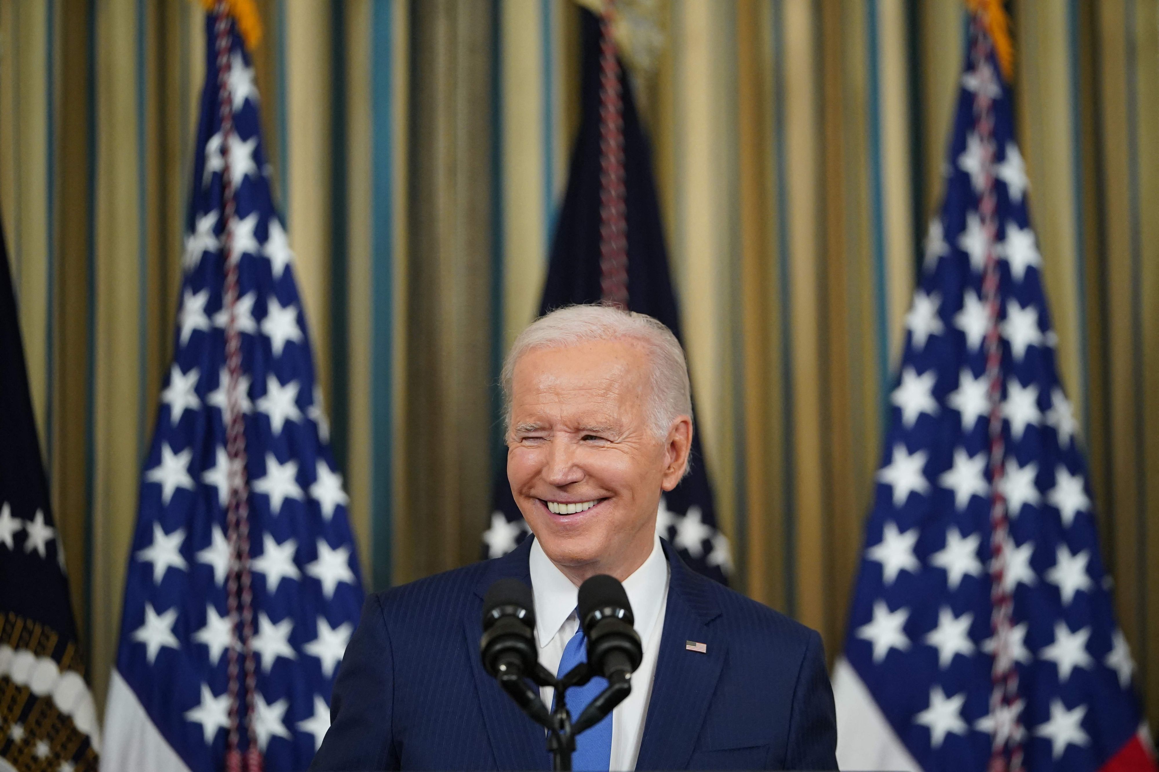 US-Präsident Joe Biden steht am 9.11.2022 während einer Pressekonferenz lächelnd vor US-Flaggen