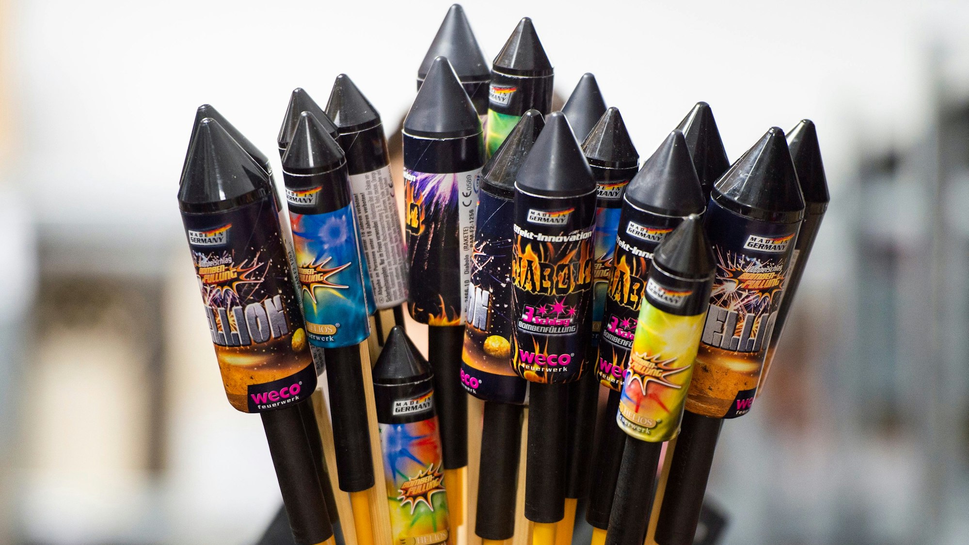 Eine Person hält eine handvoll Silvesterraketen.