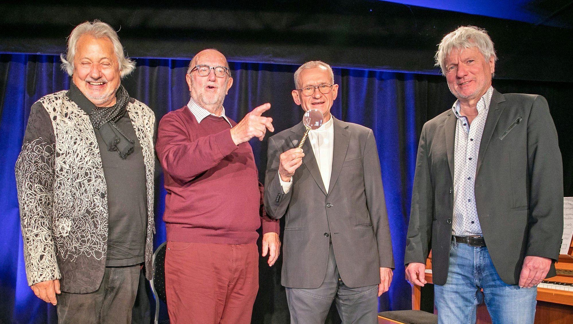Konrad Beikircher, Klaus Grewe, Preisträger Franz Meurer und Jürgen Becker stehen am 13. November 2022 lachend auf der Bühne im Morenhovener Krea-Theater