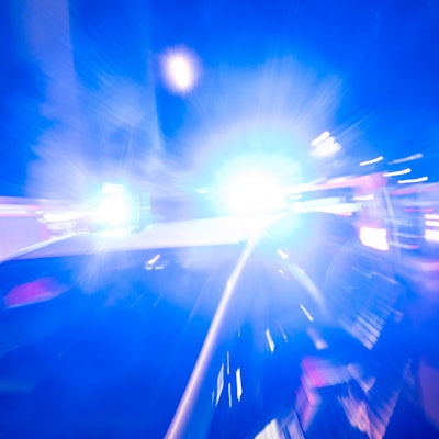 Ein Polizeiauto steht vor einem Haus, das Blaulicht strahl grell.